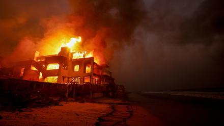 09.01.2025, USA, Malibu: Das Palisades-Feuer brennt auf einem Grundstück am Strand.