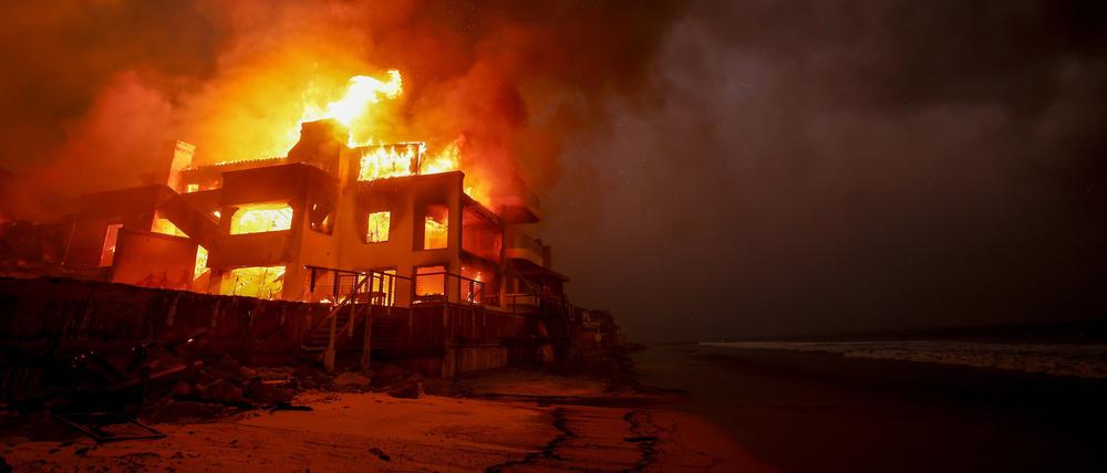 09.01.2025, USA, Malibu: Das Palisades-Feuer brennt auf einem Grundstück am Strand.