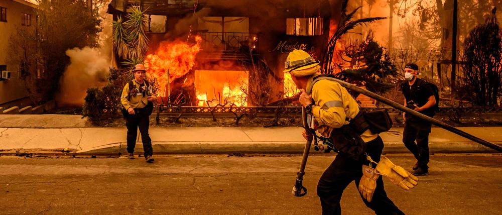 Feuerwehrleute in Los Angeles versuchen, Häuser vor den Flammen zu retten.