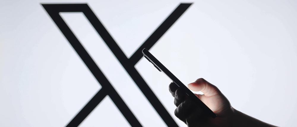 Logos displayed on smartphones in Paraguay - 05 Sept 2024 In this photo illustration, the X Twitter logo seen in the background with a silhouette hand holding a smartphone. Paraguay Copyright: xJaquexSilvax/xSOPAxImagesx JAQUESILVA_05092024-6084
