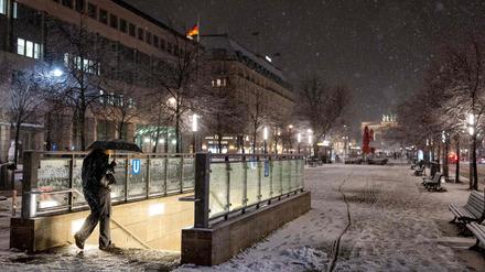 Eine Frau betritt den U-Bahnhof Brandenburger Tor, während es draußen schneit.