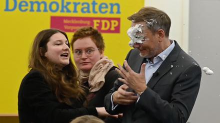 Der FDP-Vorsitzende Christian Lindner bekommt bei einem Wahlkampfauftritt in Greifswald von der Linke-Lokalpolitikerin Christiane Kiesow Schaum ins Gesicht geworfen.