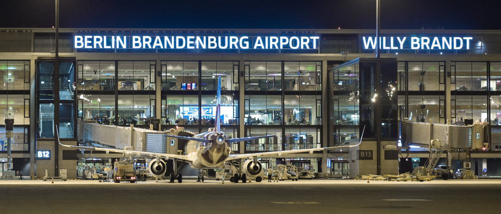 Ein Flugzeug steht vor dem Flughafen BER auf dem Rollfeld.