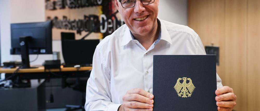 Der Präsident des Hauses der Geschichte, Harald Biermann, zeigt die Mappe mit der „Zeitenwende“-Rede von Olaf Scholz.  