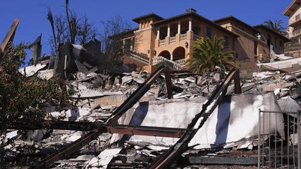 12.01.2025, USA, Malibu: Ein Haus steht über den Trümmern des Palisades Fire in Malibu, Kalifornien.