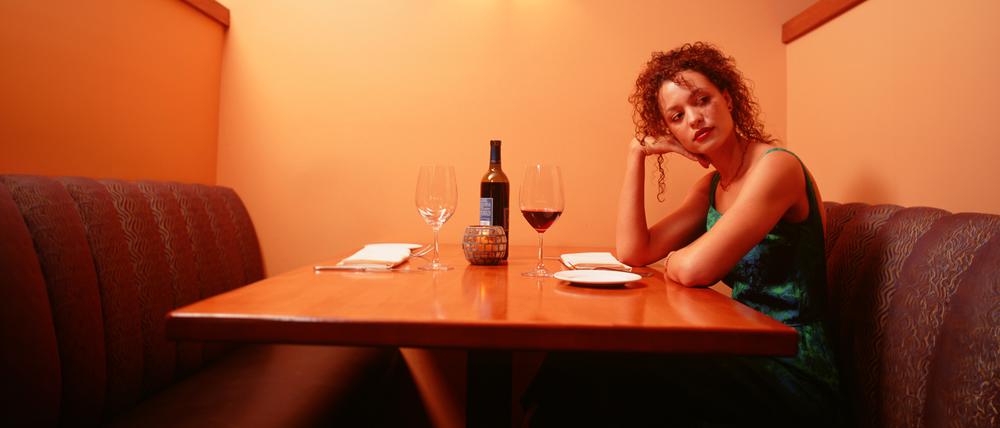 Frau wartet auf ihr Date in einer Bar.
