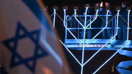 Uwe Becker (CDU, 2.v.r.), Antisemitismusbeauftrager des Landes Hessen, nimmt auf dem Opernplatz am öffentlichen Lichterzünden des Chanukka-Leuchters anlässlich des Chanukka-Festes teil.