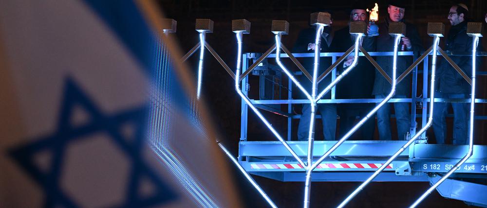 Uwe Becker (CDU, 2.v.r.), Antisemitismusbeauftrager des Landes Hessen, nimmt auf dem Opernplatz am öffentlichen Lichterzünden des Chanukka-Leuchters anlässlich des Chanukka-Festes teil.