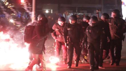Polizisten stehen in der Silvesternacht zwischen brennendem Feuerwerk. (Symbolbild)