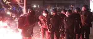 Polizisten stehen in der Silvesternacht zwischen brennendem Feuerwerk. (Symbolbild)