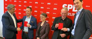 Die Berliner SPD mit Fraktionschef Raed Saleh (l) überreicht zwei neuen Mitgliedern ihr Parteibuch.