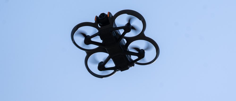 Eine Drohne mit einer Kamera fliegt durch die Luft.