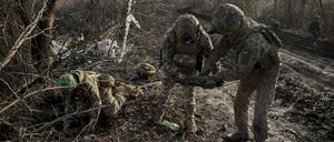 12.01.2025, Ukraine, Chasiv Jar: Ukrainische Soldaten sammeln beschädigte Munition auf der Straße an der Frontlinie in der Nähe der Stadt Chasiv Yar in der Region Donezk ein.