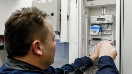 Ein Elektriker montiert einen digitalen Stromzähler mit einem Smart-Meter-Gateway zur Datenübertragung.