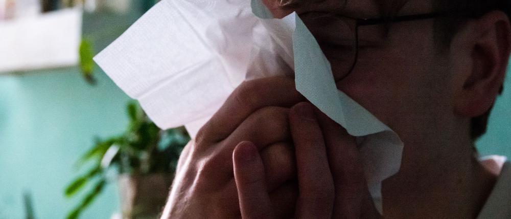 Für eine Grippe typische ist oft ein plötzlicher Erkrankungsbeginn mit Fieber, Muskel- oder Kopfschmerzen (Symbolbild).
