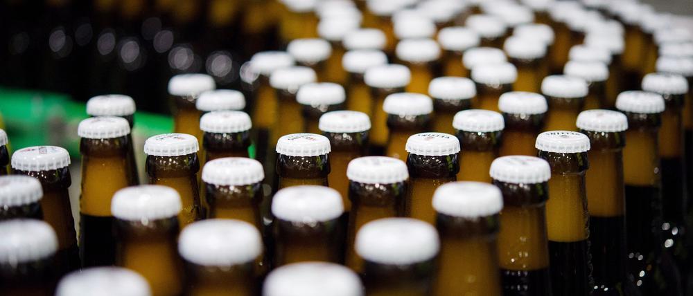 Bierflaschen mit Kronkorken laufen durch die Produktion der Veltins-Brauerei in Meschede-Grevenstein über die Förderbänder einer Befüllungsanlage.