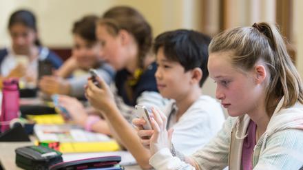 Medienkompetenz vermitteln:Schüler am Handy im Unterricht