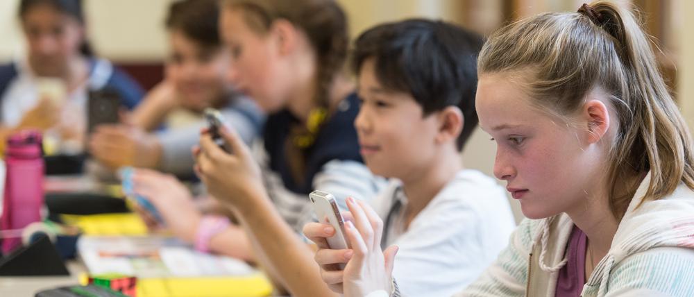 Medienkompetenz vermitteln:Schüler am Handy im Unterricht