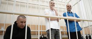 Die ehemaligen Anwälte des gestorbenen russischen Oppositionellen Nawalny, Igor Sergunin (l-r), Alexei Lipzer und Wadim Kobsew, sitzen und stehen während einer Gerichtssitzung in Petuschki, Region Wladimir, etwa 120 Kilometer östlich von Moskau, in einem Käfig.