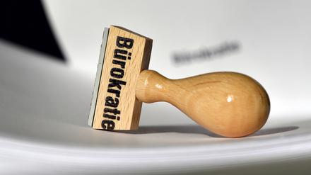 ARCHIV - 12.02.2015, Brandenburg, Potsdam: Ein Stempel mit der Aufschrift «Bürokratie» liegt auf Papieren. (zu dpa: «Wirtschaft kritisiert wenig Fortschritt bei Bürokratieabbau») Foto: Ralf Hirschberger/dpa-Zentralbild/dpa +++ dpa-Bildfunk +++