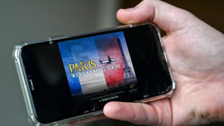 Ein Mann sieht sich auf seinem Handy in Islamabad am 17. Januar 2025 eine Werbung der Pakistan International Airlines (PIA) an, die den Eiffelturm anfliegt. Pakistans umkämpfte nationale Fluggesellschaft entschuldigte sich am 17. Januar für eine Anzeige, die ein Flugzeug beim Anflug auf den Eiffelturm zeigt und anlässlich des ersten Fluges nach Paris nach Aufhebung des Sicherheitsverbots veröffentlicht wurde.