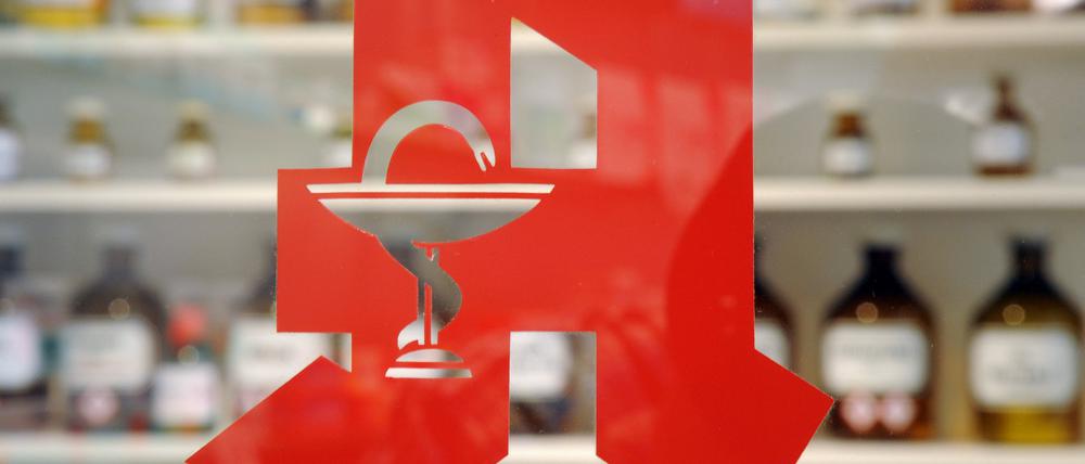 Das Logo an der Tür einer Apotheke.