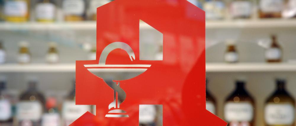 Das Logo an der Tür einer Apotheke. 
