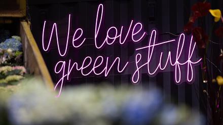 „We love green stuff“ steht an einer Wand in einer Messehalle auf der Grünen Woche. 