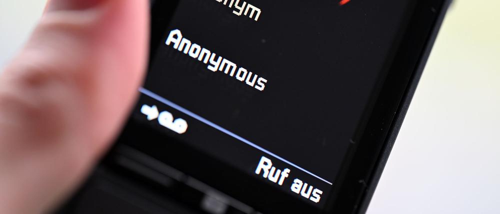 ILLUSTRATION - Ein Mann hält ein Festnetz-Telefon, auf dem ein anonymer Anruf eingeht (gestellte Szene).