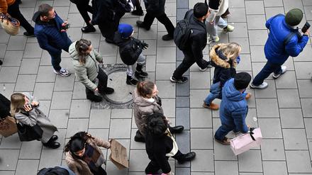Männer und Frauen mit Einkaufstüten gehen durch die Fußgängerzone, der Einkaufsmeile der Landeshauptstadt München.