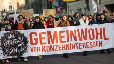18.01.2025, Berlin: Menschen laufen auf der Demonstration «Wir haben es satt!» für eine Agrarwende durch das Berliner Regierungsviertel mit einem Banner mit der Aufschrift «Gemeinwohl vor Konzerninteressen».