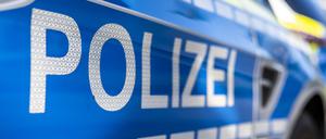 An der Tür von einem Streifenwagen steht der Schriftzug „Polizei“.