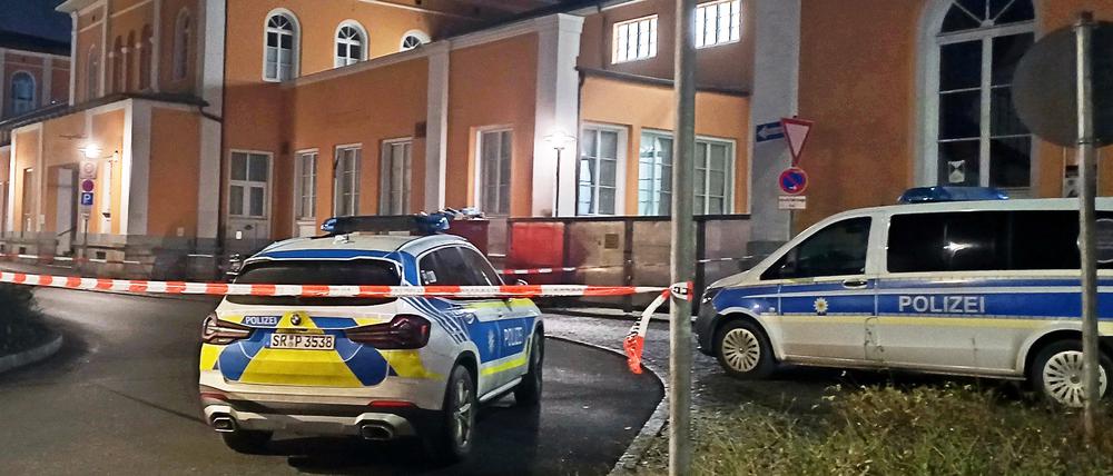 Einsatzfahrzeuge der Polizei stehen vor dem abgesperrten Hauptbahnhof in Passau.
