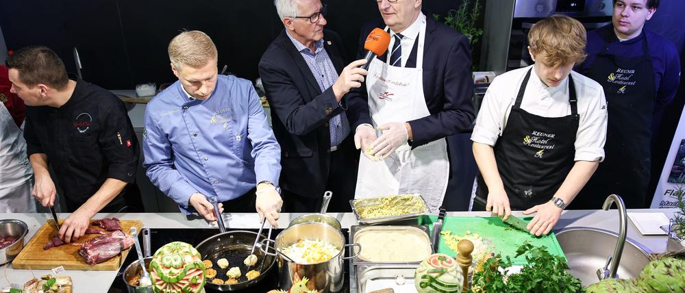 Bei der Grünen Woche darf in der Brandenburg-Halle auch geschlemmt werden, aber der Ausbruch der Maul- und Klauenseuche trübt die Stimmung. 