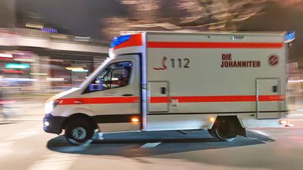 Ein Rettungswagen fährt in hoher Geschwindigkeit und mit Blaulicht durch die Nacht. (Symbolbild)