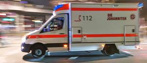 Ein Rettungswagen fährt in hoher Geschwindigkeit und mit Blaulicht durch die Nacht. (Symbolbild)