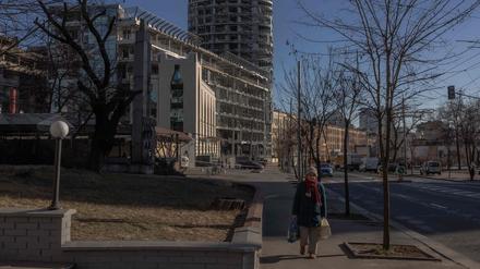 Ältere Frau beim Gang durch ein teils zerstörtes Viertel der ukrainischen Hauptstadt Kiew.