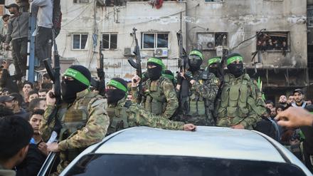Kämpfer der Qassam-Brigaden, des militärischen Flügels der Hamas, stehen auf einem Auto, als Fahrzeuge des Roten Kreuzes zur Abholung israelischer Geiseln, die im Rahmen eines Waffenstillstandsabkommens zwischen Israel und der Hamas freigelassen wurden, in Gaza-Stadt rangieren. 