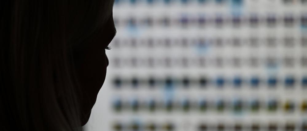 Eine Ermittlerin sitzt im Landeskriminalamt Hessen vor einem Monitor mit Fotodateien.