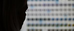 Eine Ermittlerin sitzt im Landeskriminalamt Hessen vor einem Monitor mit Fotodateien.