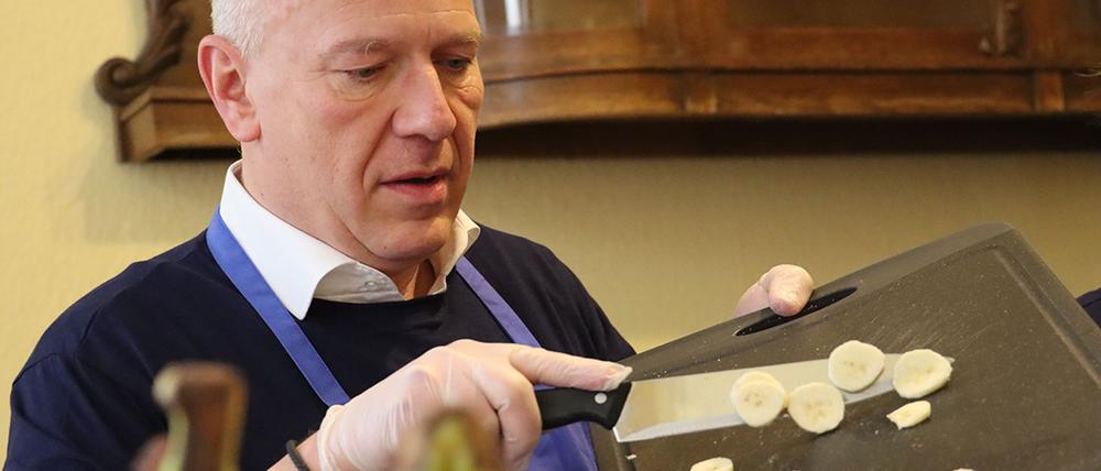 Der Regierende Bürgermeister Kai Wegner hilft beim Kochen für arme Menschen in der Wärmestube in Neukölln.