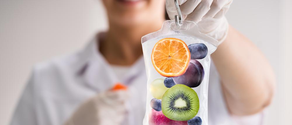 Die Infusionsbeutel sollen unter anderem Vitamine enthalten, hier ein Symbolbild: Eine Frau hält den Beutel in der Hand. Darin sind Früchte zu sehen.