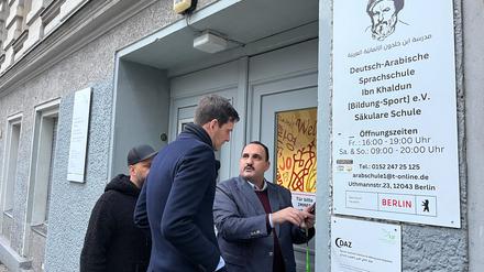 Schulleiter Hudhaifa Al-Mashhadani zeigt Bezirksbürgermeister Martin Hikel Bilder der Drohungen.