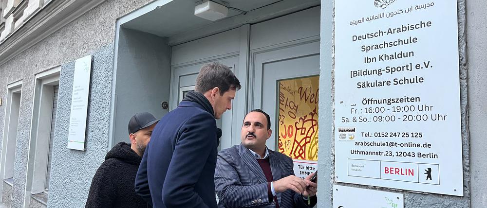 Schulleiter Hudhaifa Al-Mashhadani zeigt Bezirksbürgermeister Martin Hikel Bilder der Drohungen.