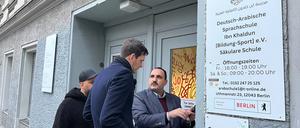 Schulleiter Hudhaifa Al-Mashhadani zeigt Bezirksbürgermeister Martin Hikel Bilder der Drohungen.