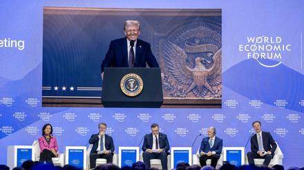 US President Donald Trump is seen on a giant screen during his address by video conference at the World Economic Forum (WEF) annual meeting in Davos on January 23, 2025. (Photo by FABRICE COFFRINI / AFP)