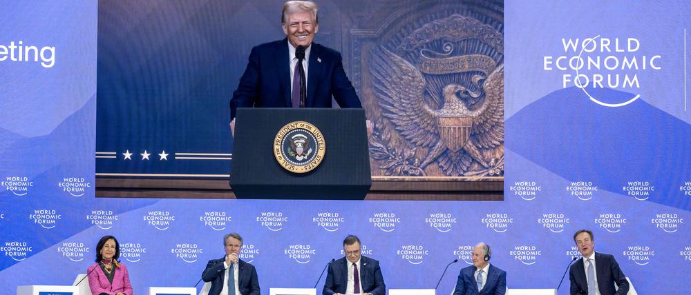 US President Donald Trump is seen on a giant screen during his address by video conference at the World Economic Forum (WEF) annual meeting in Davos on January 23, 2025. (Photo by FABRICE COFFRINI / AFP)