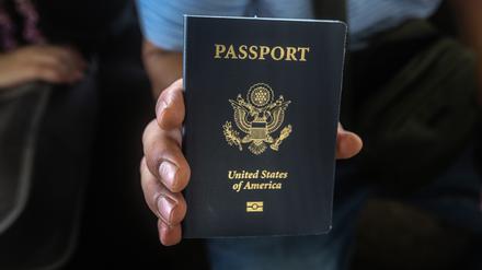 Ein US-Bürger hält seinen Reisepass in der Hand.