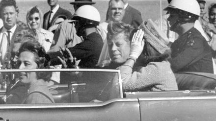 US-Präsident John F. Kennedy winkt aus seinem Auto in einer Autokolonne in Dallas, zusammen mit der First Lady Jacqueline «Jackie» Kennedy