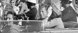  US-Präsident John F. Kennedy winkt aus seinem Auto in einer Autokolonne in Dallas, zusammen mit der First Lady Jacqueline «Jackie» Kennedy